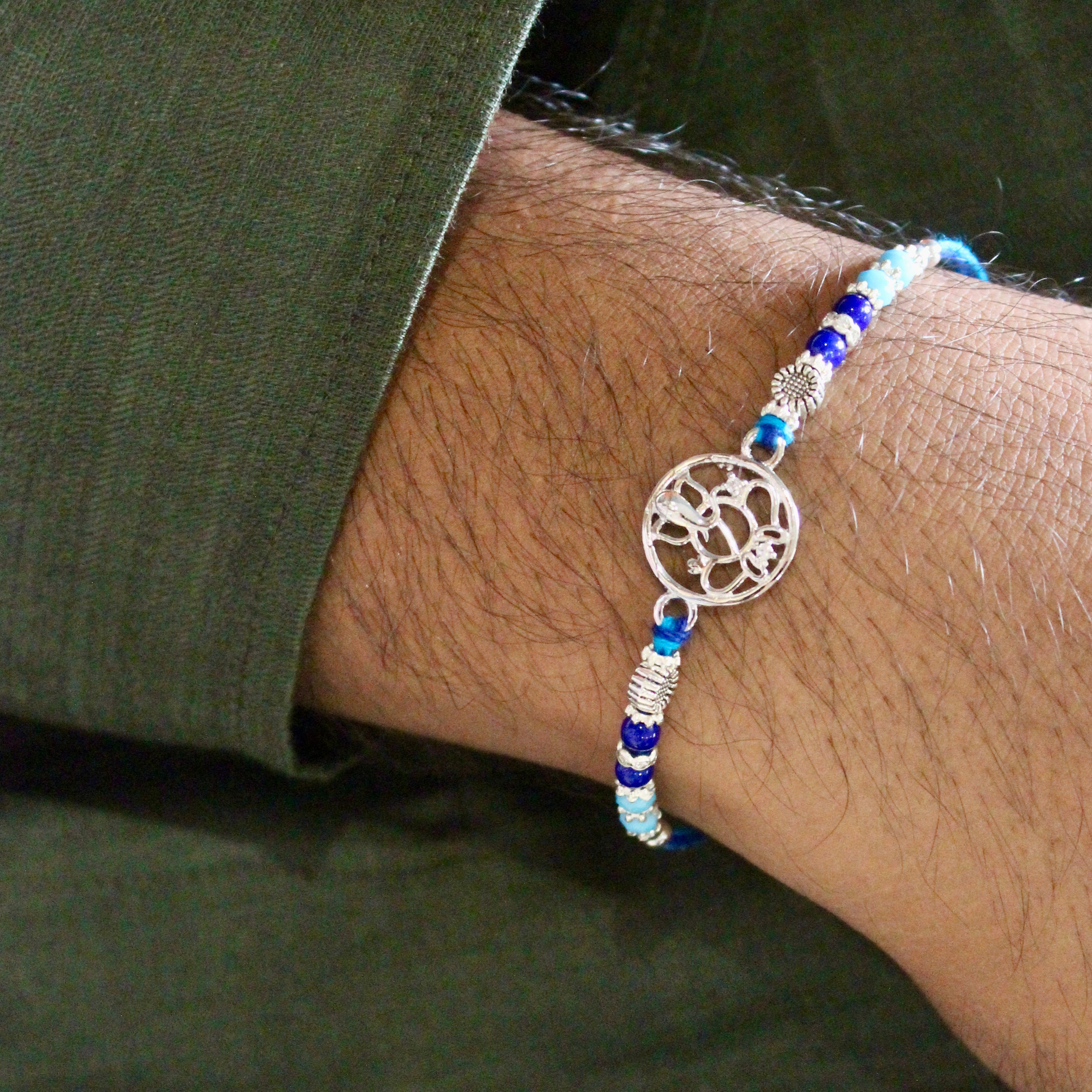 Ganesha in circle blue thread rakhi in 925 silver