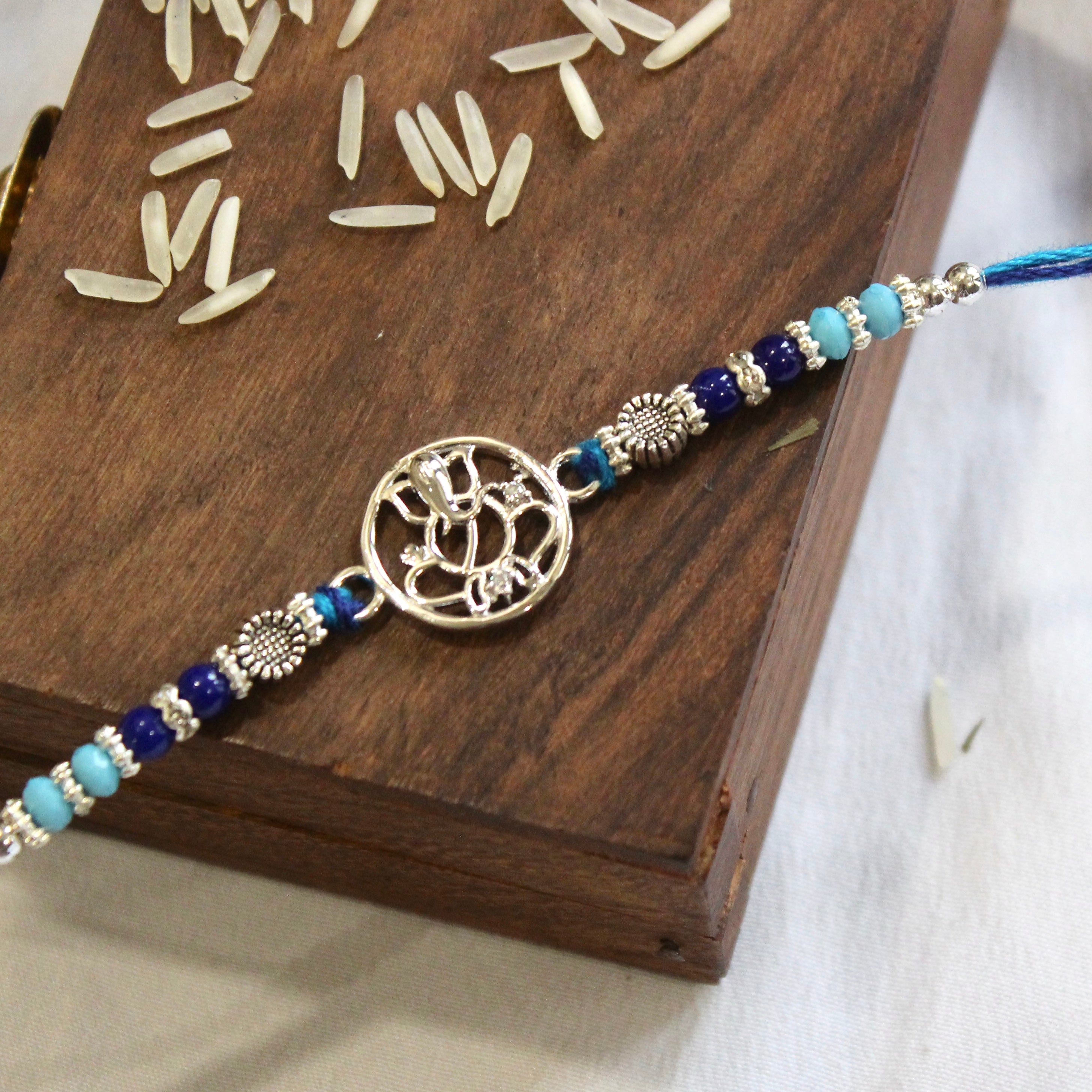 Ganesha in circle blue thread rakhi in 925 silver