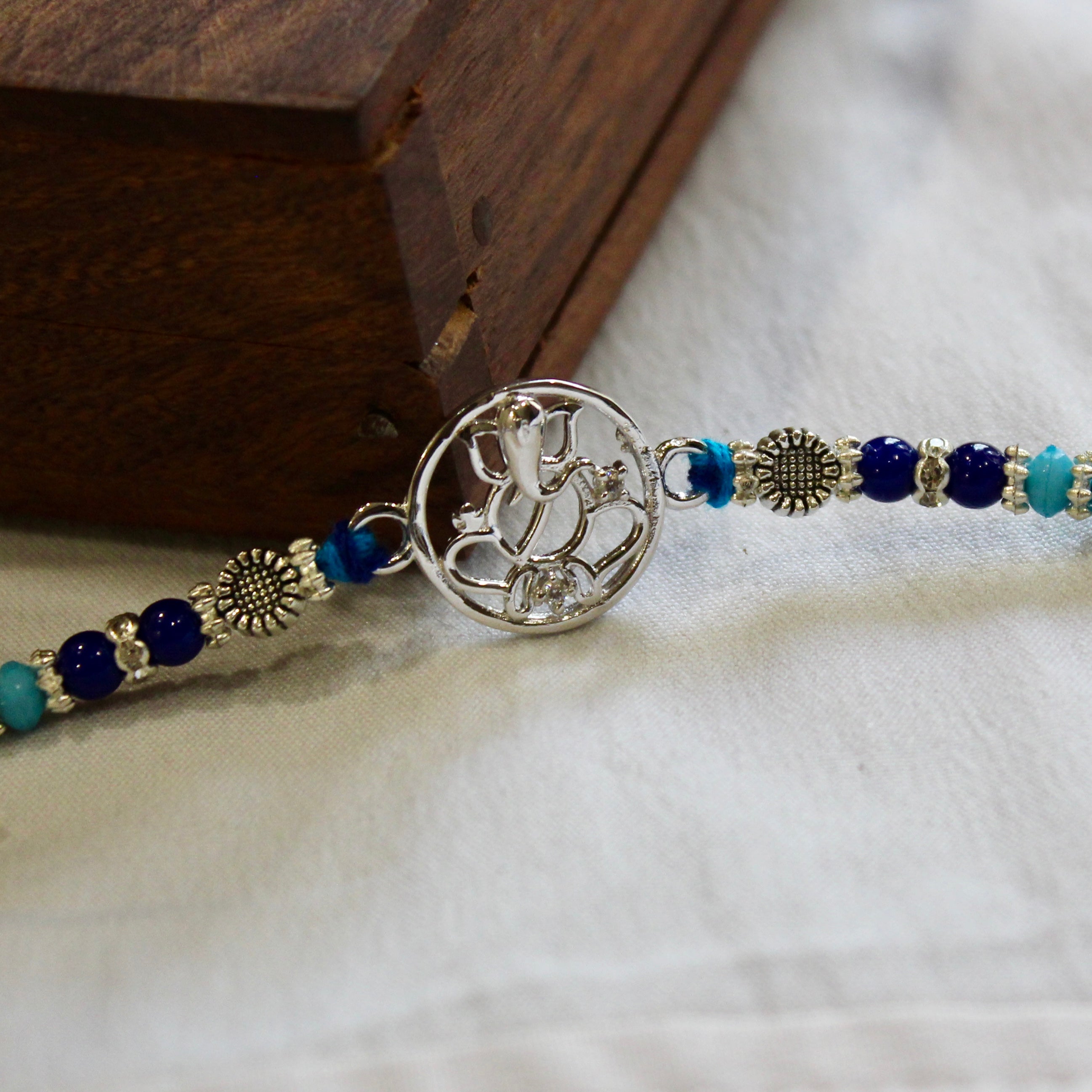Ganesha in circle blue thread rakhi in 925 silver
