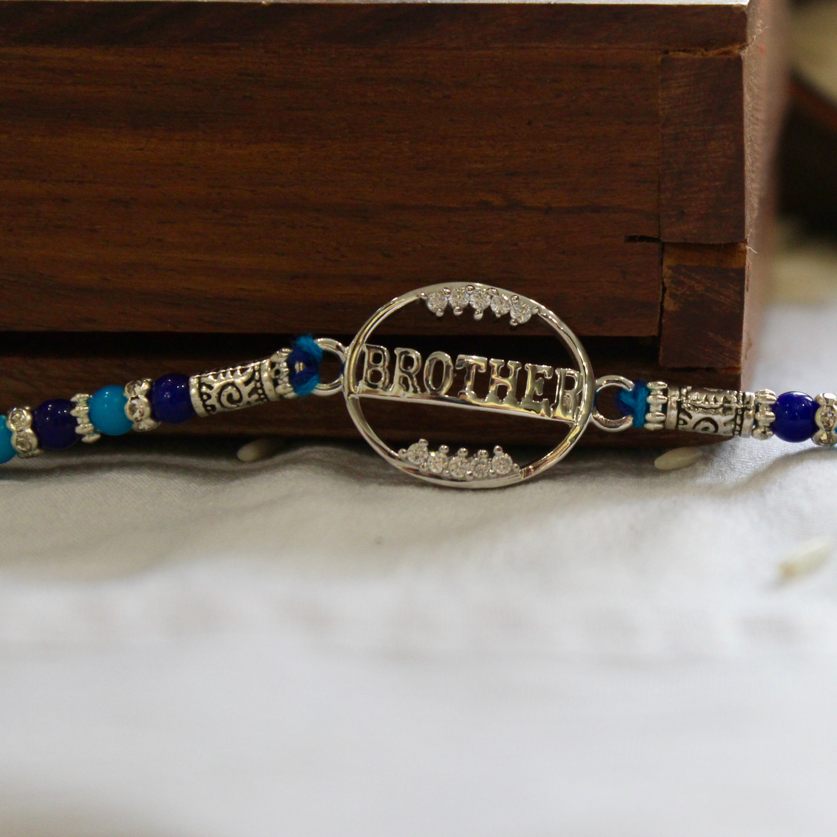 'BROTHER' blue thread rakhi in 925 silver