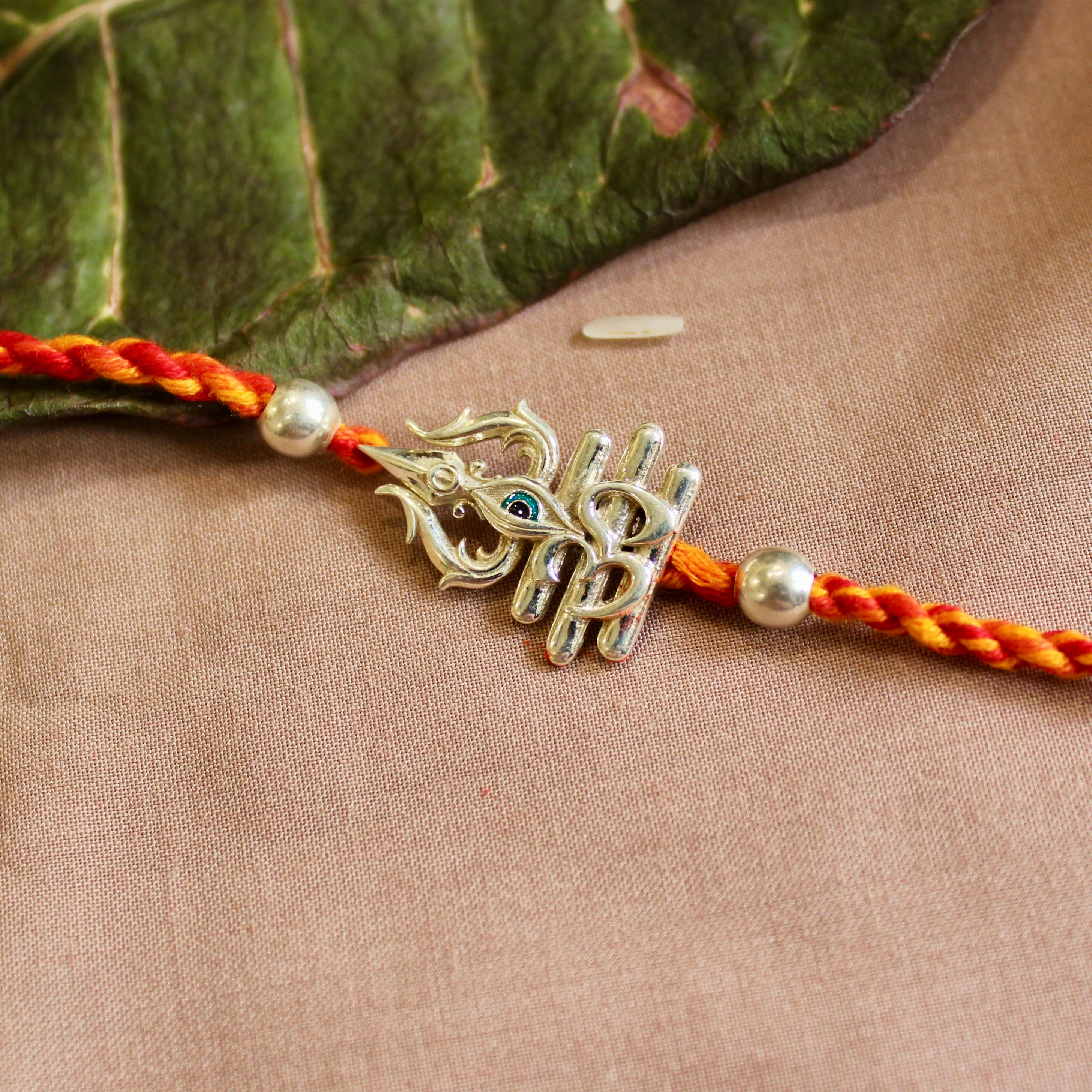 'Trishul with eye' red yellow thread rakhi in 925 Silver