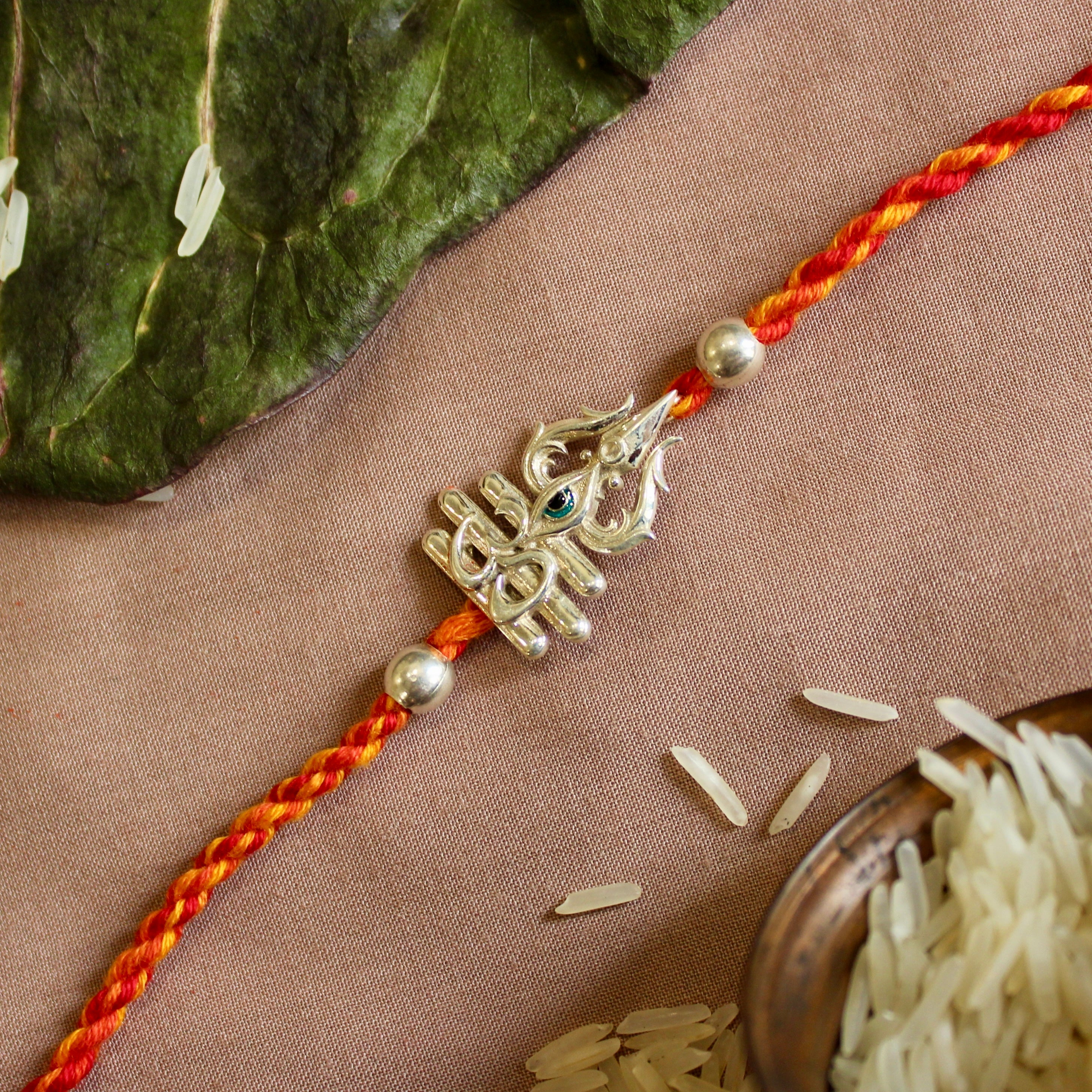 'Trishul with eye' red yellow thread rakhi in 925 Silver