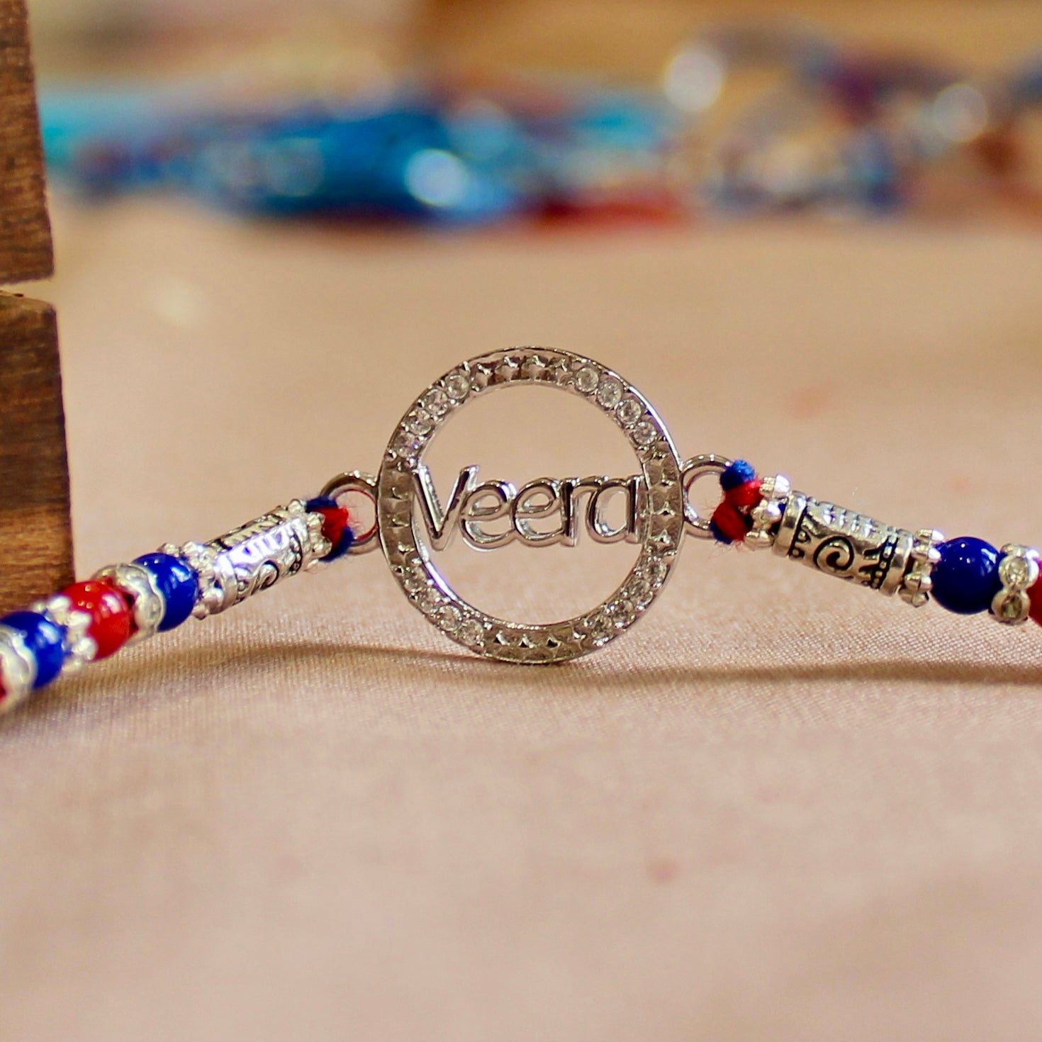 'VEERA in circle' red thread rakhi in 925 silver