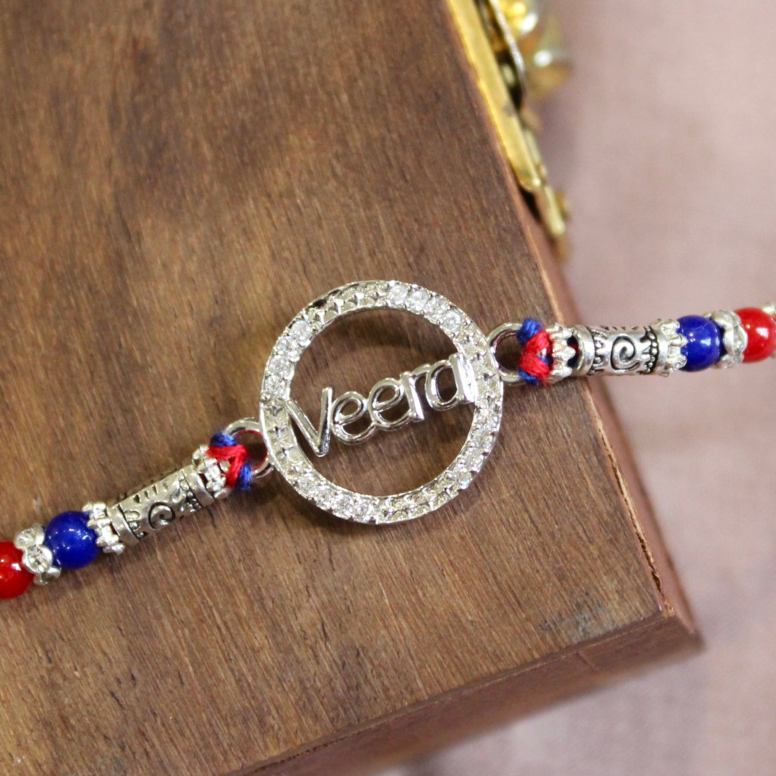 'VEERA in circle' red thread rakhi in 925 silver