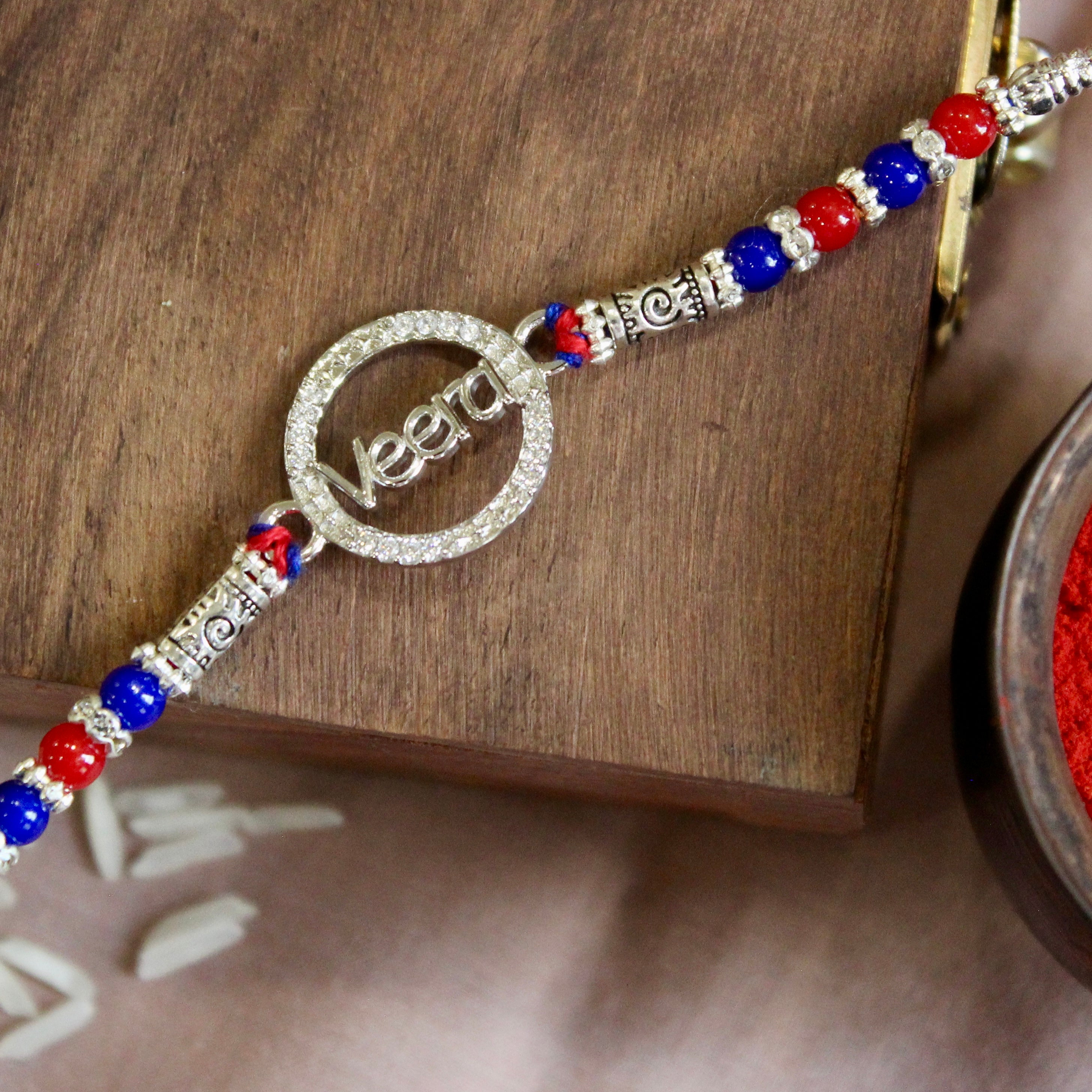 'VEERA in circle' red thread rakhi in 925 silver