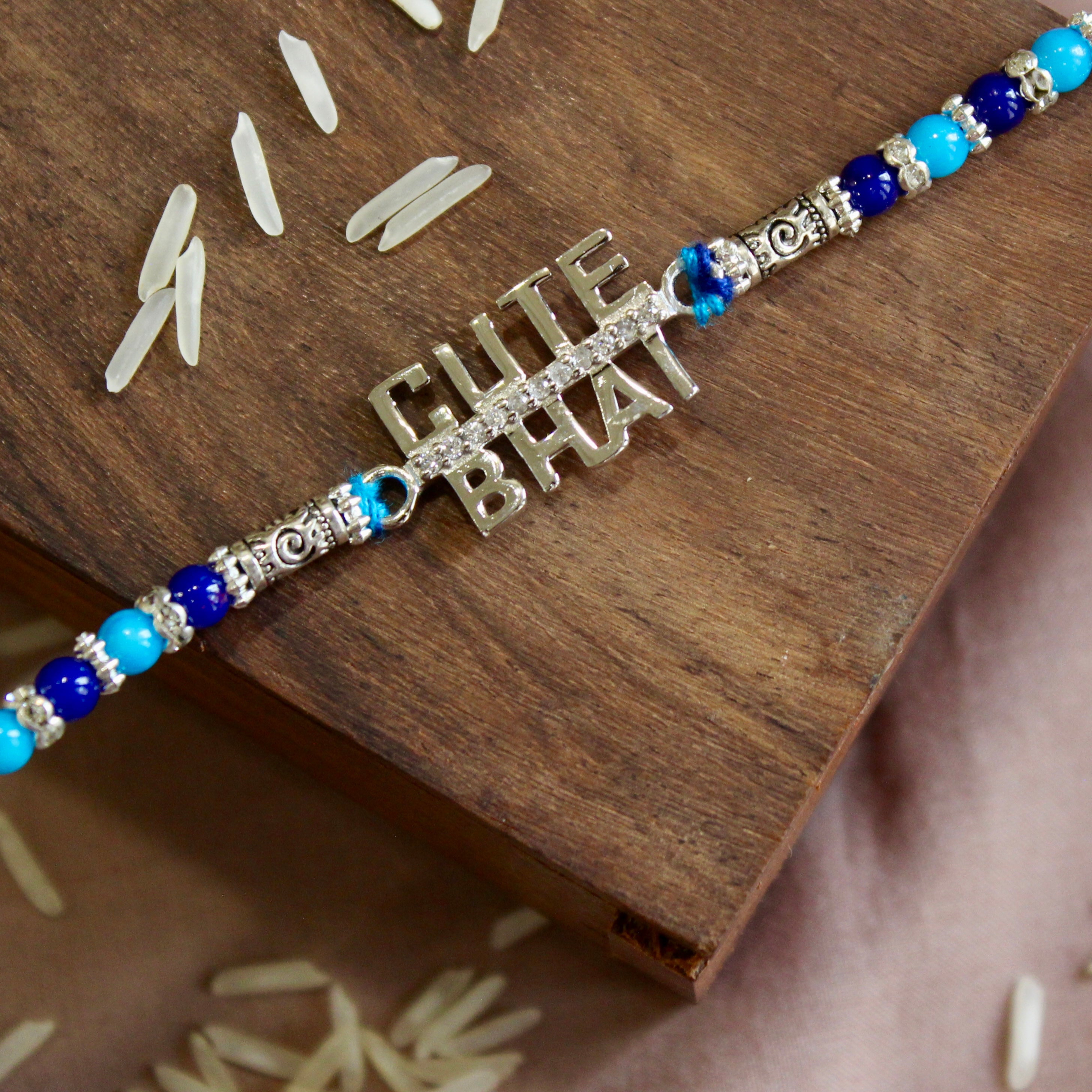 'CUTE BHAI' blue thread rakhi in 925 Silver