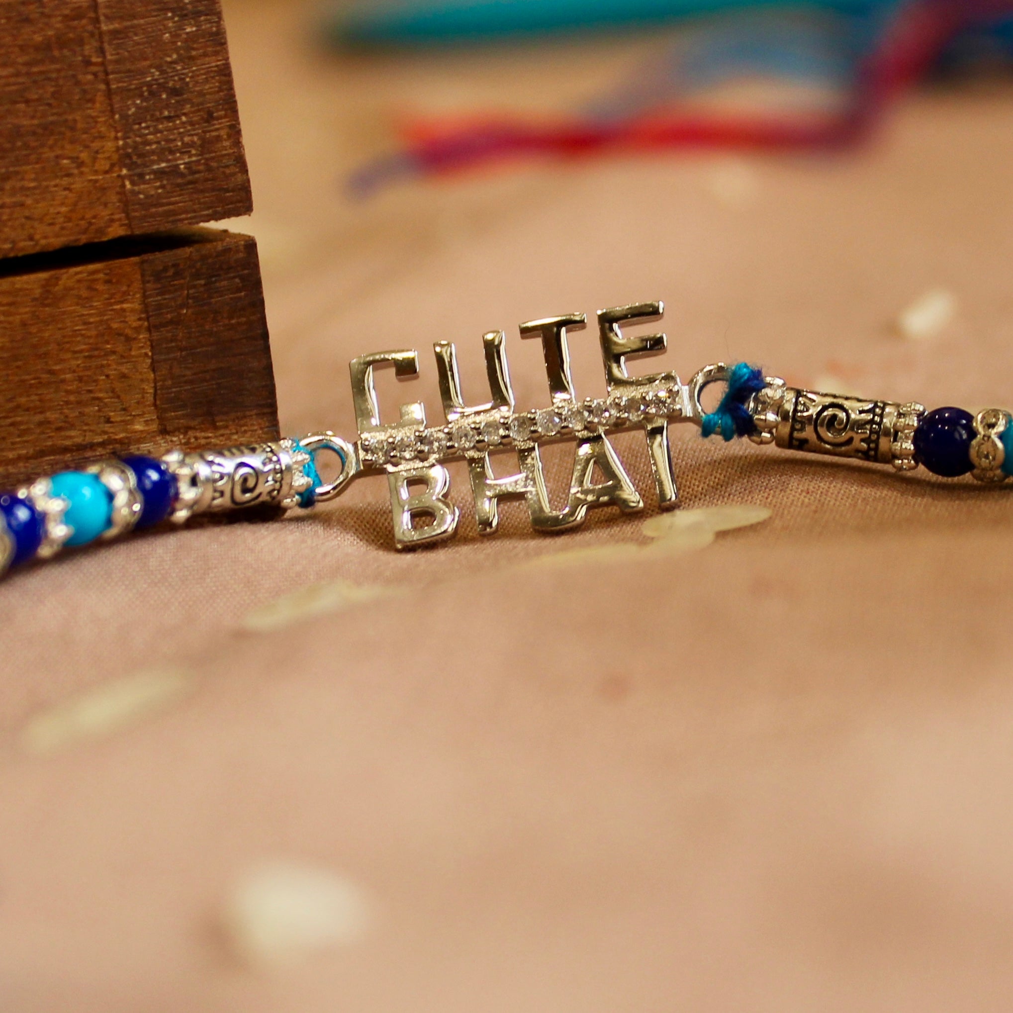 'CUTE BHAI' blue thread rakhi in 925 Silver