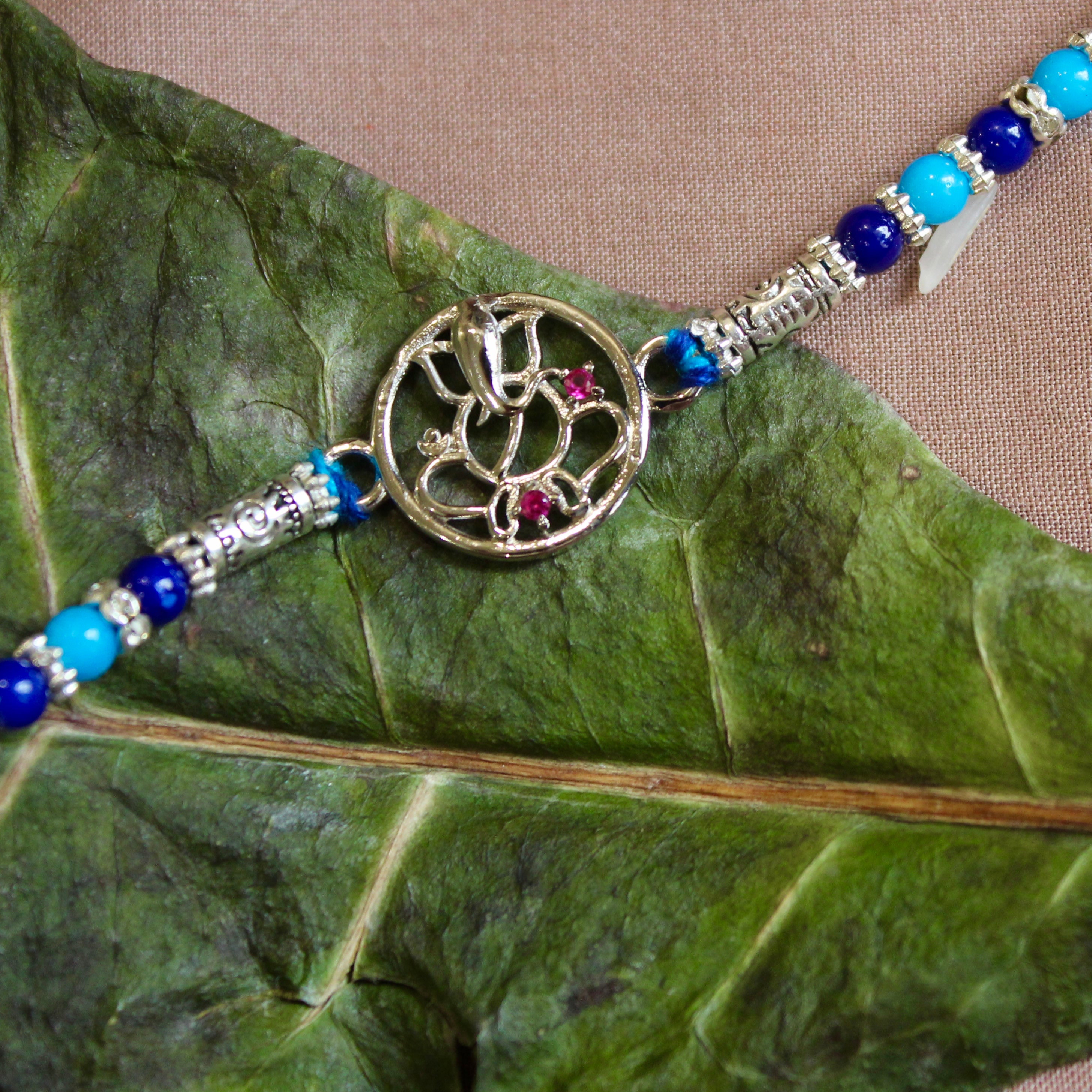 Lord ganesha with stones blue thread rakhi in 925 silver