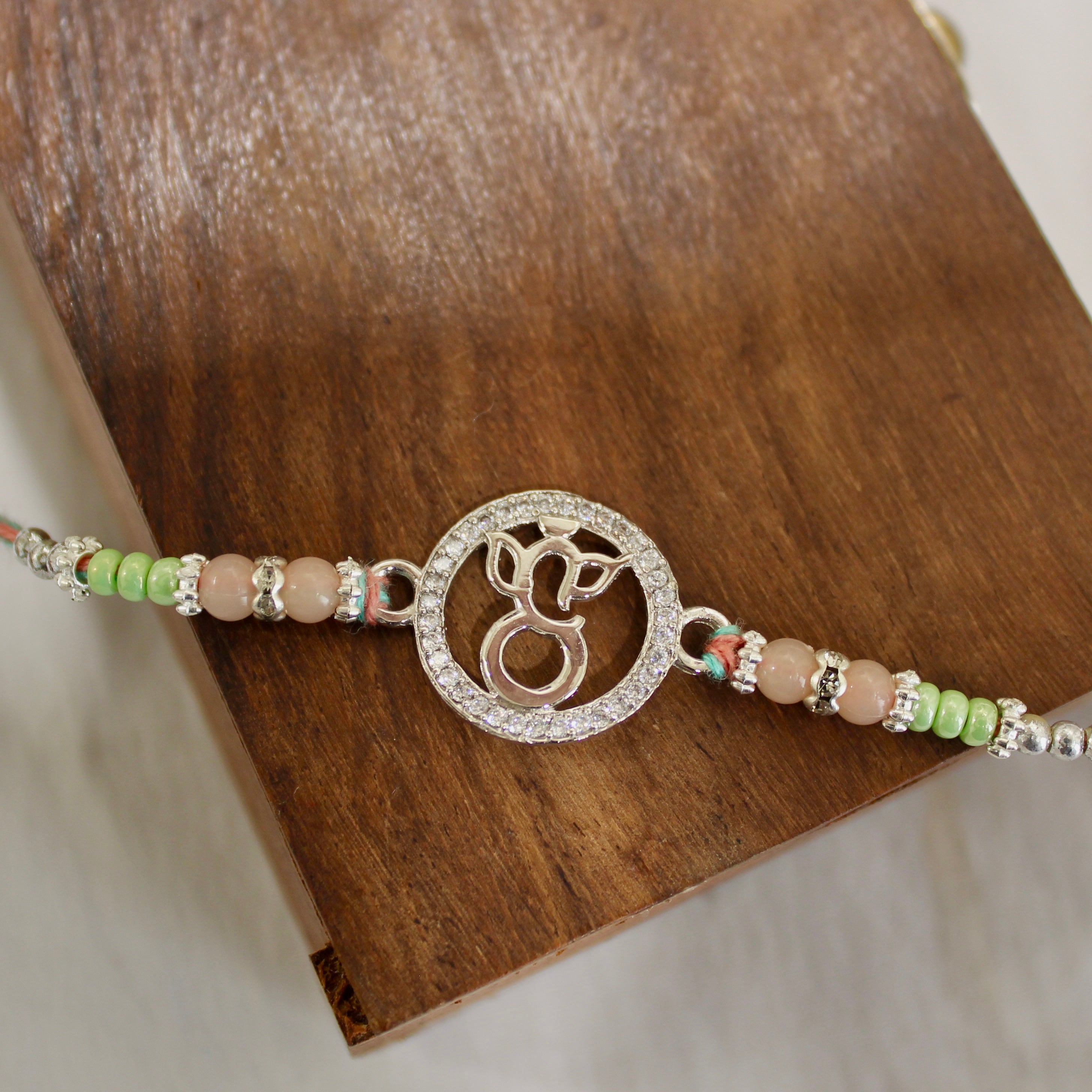 LORD GANESHA IN CIRCLE 925 silver peach thread rakhi