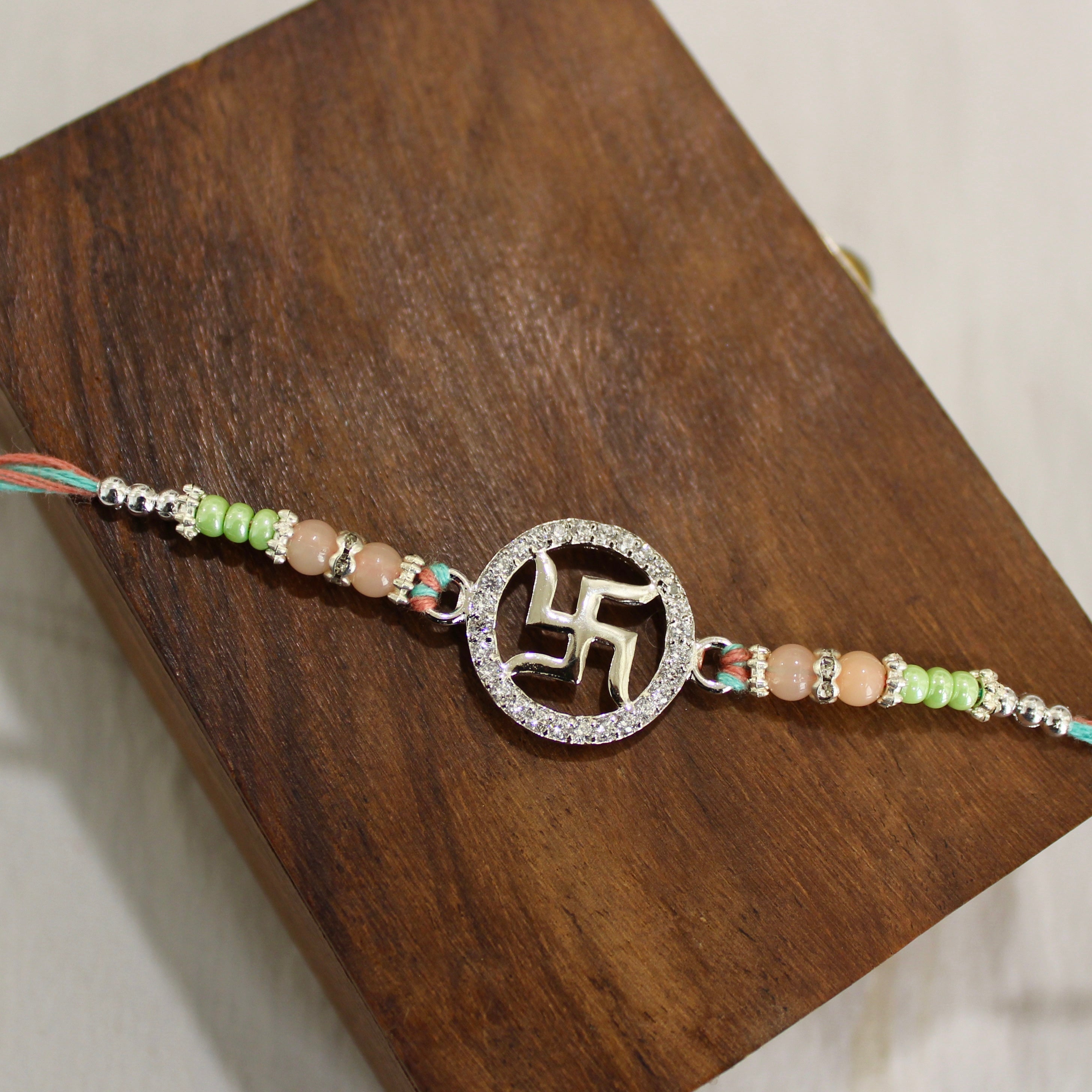 SATIYA peach thread Rakhi in 925 silver