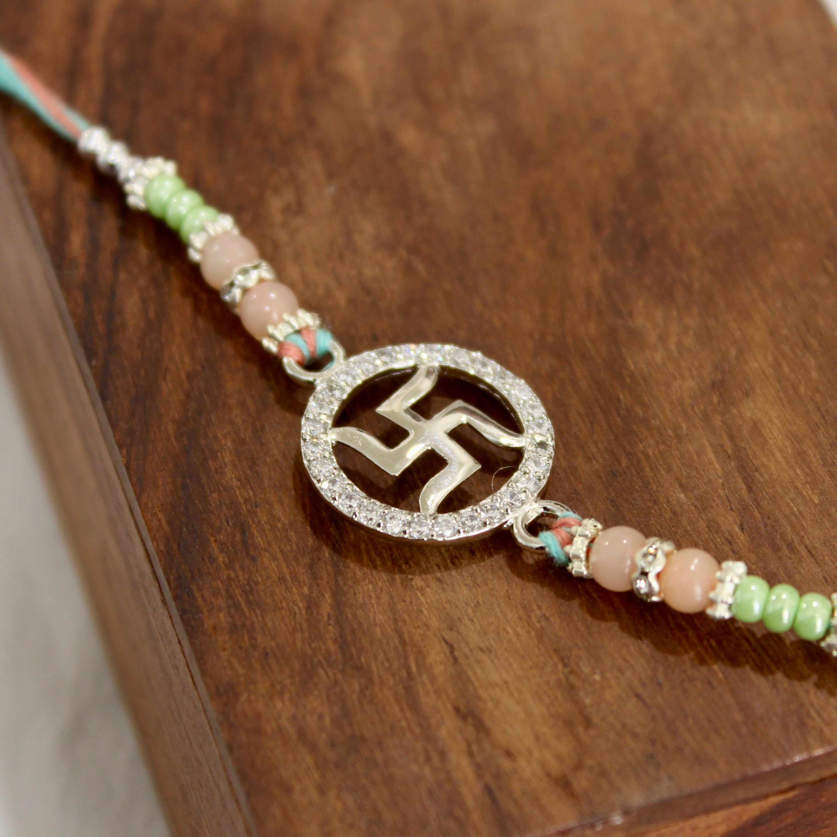 SATIYA peach thread Rakhi in 925 silver