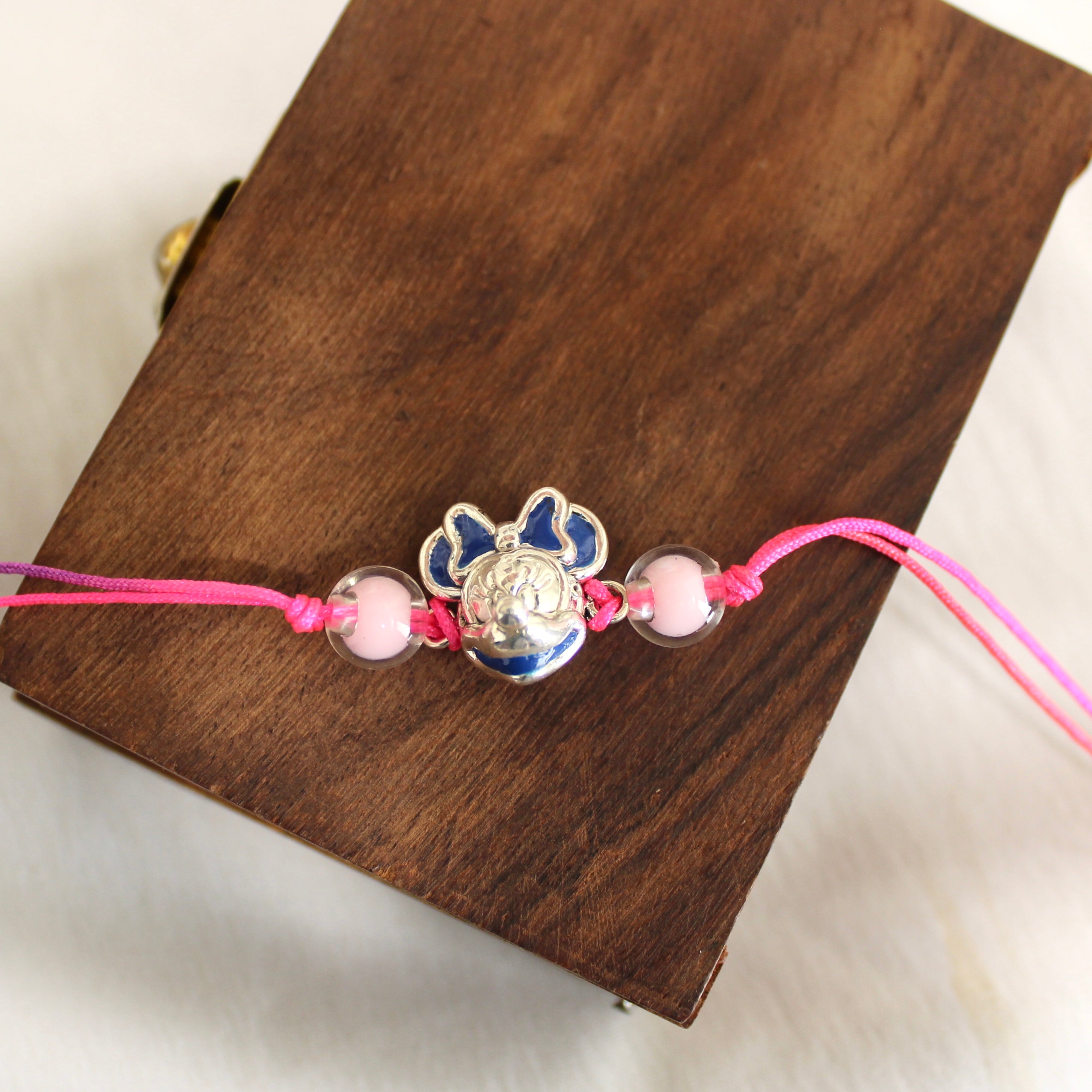 Mini pink thread rakhi in 925 silver