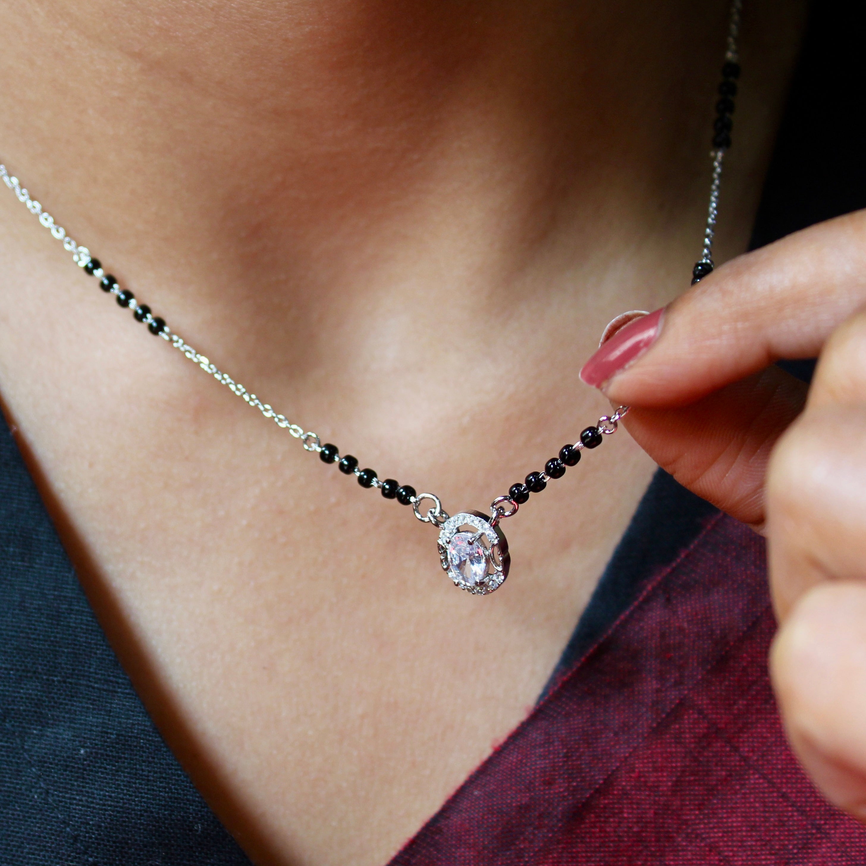 Necklace with a pendant held by a hand against a blurred background