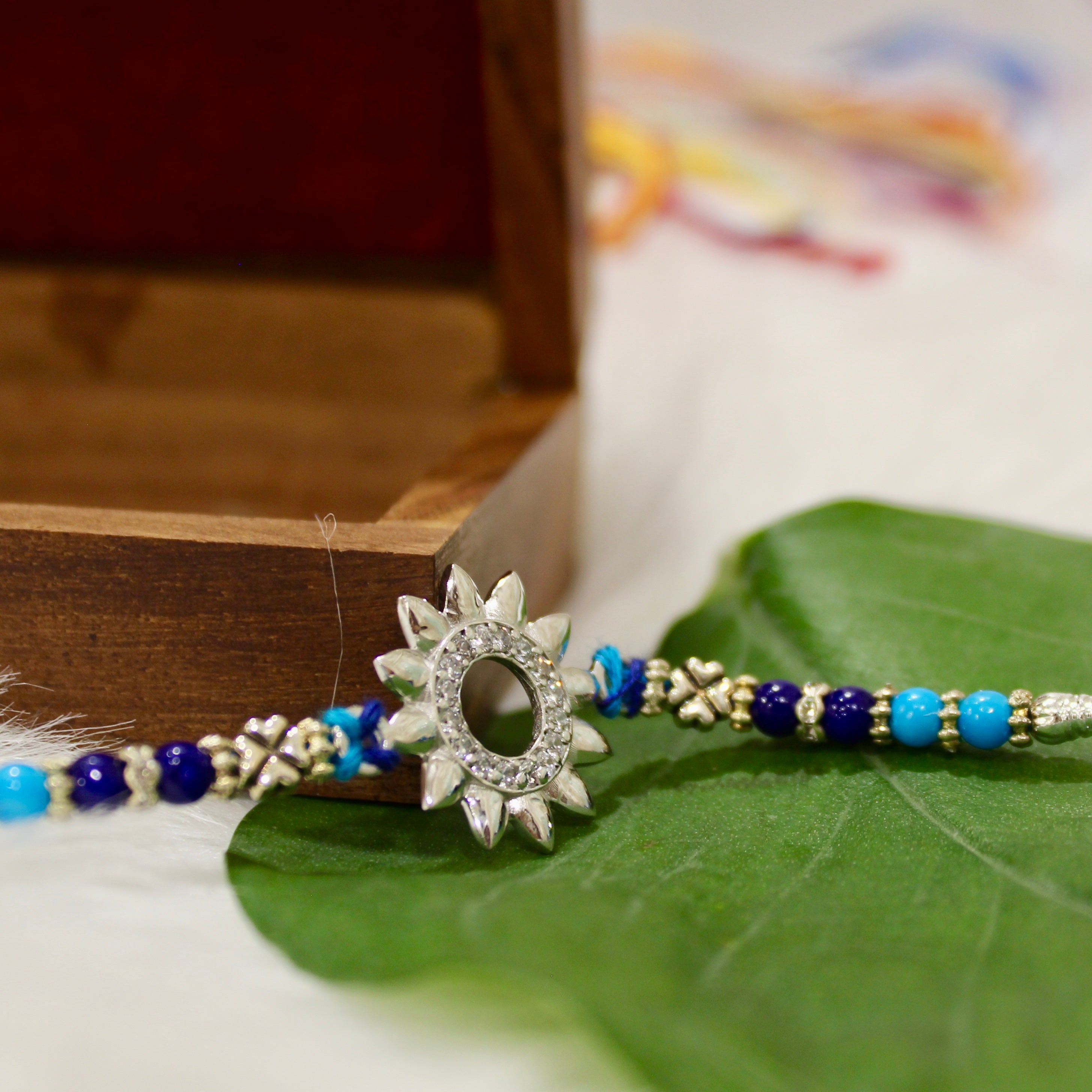 Sun Charm Blue Thread Rakhi In 925 Silver