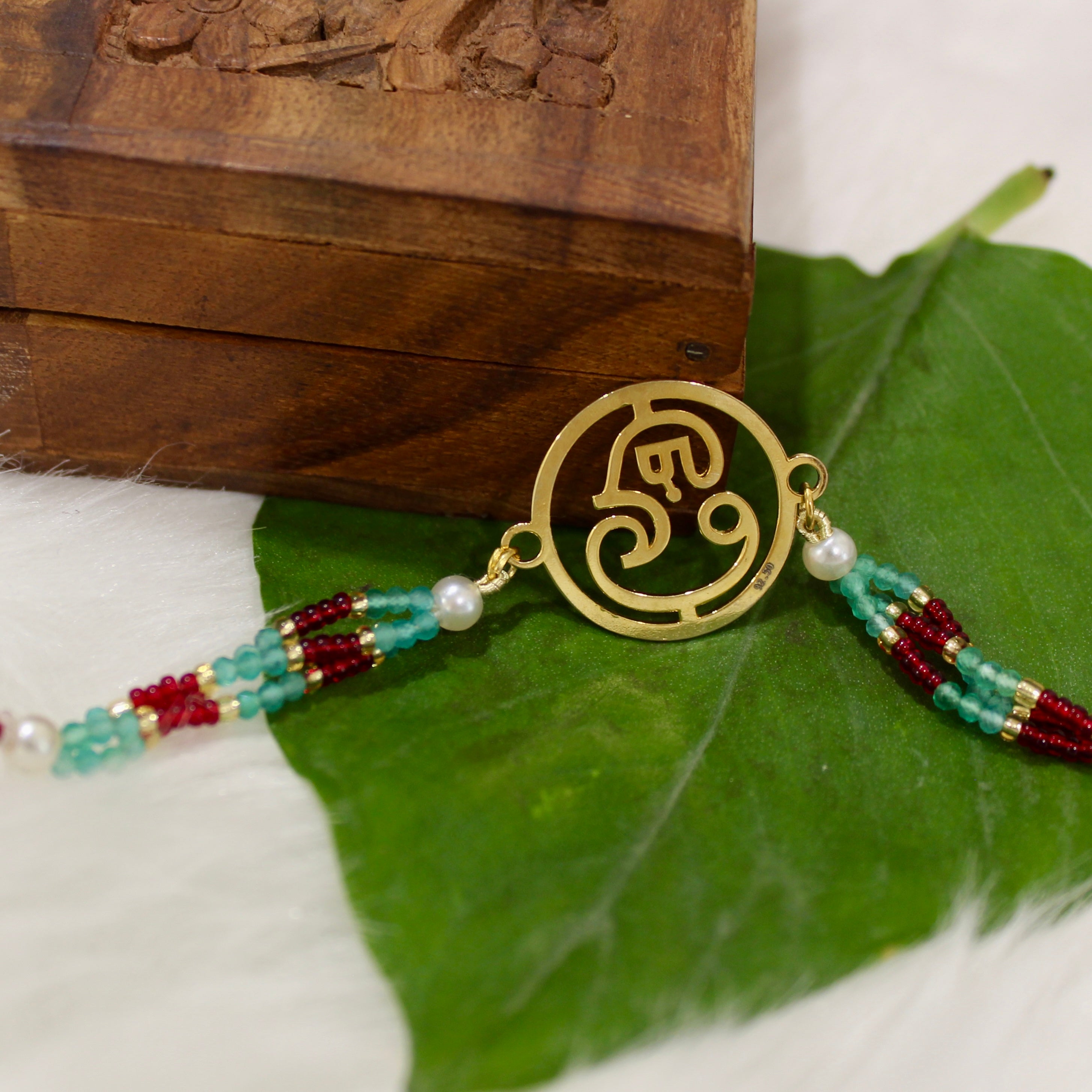Ganesha In Gold Polish Maroon Thread Rakhi in 925 Silver