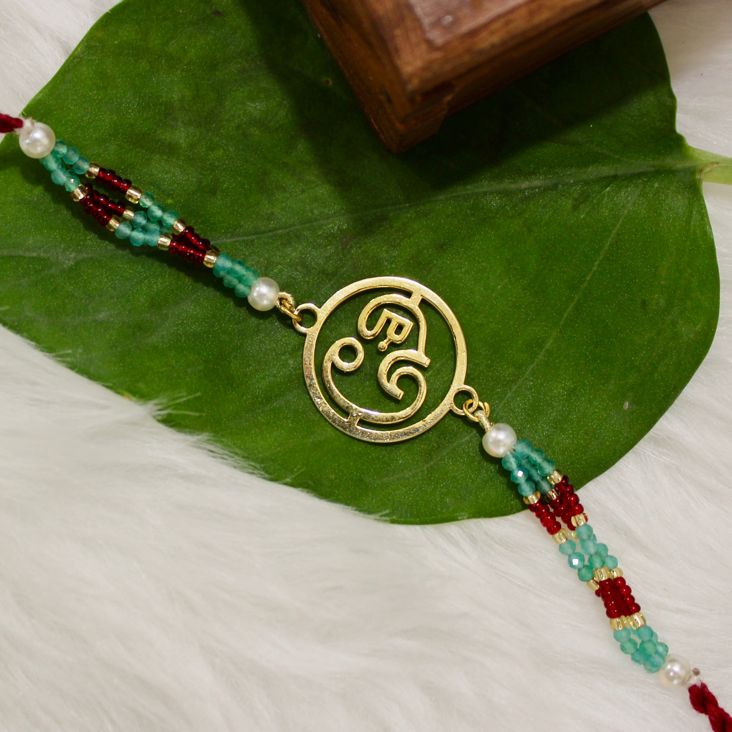 Ganesha In Gold Polish Maroon Thread Rakhi in 925 Silver