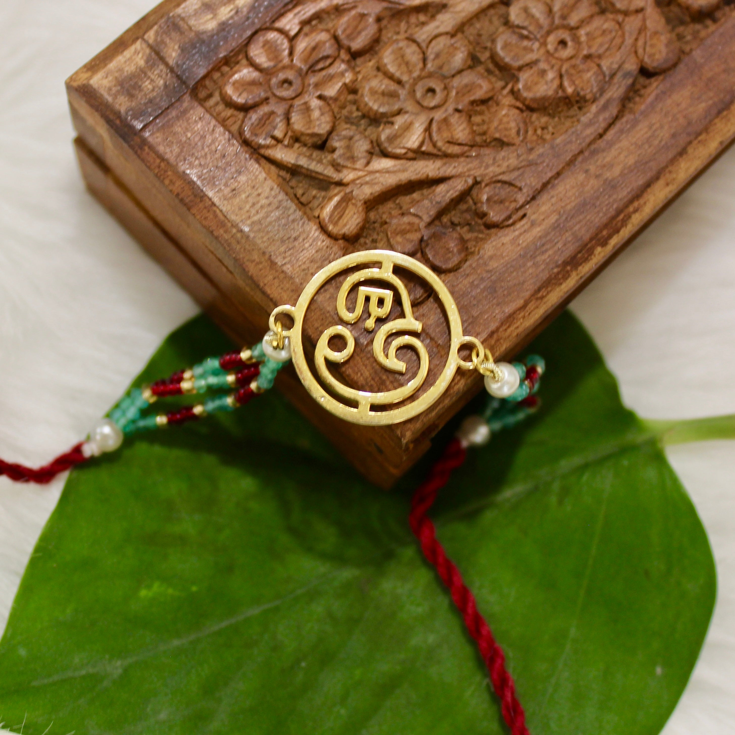 Ganesha In Gold Polish Maroon Thread Rakhi in 925 Silver