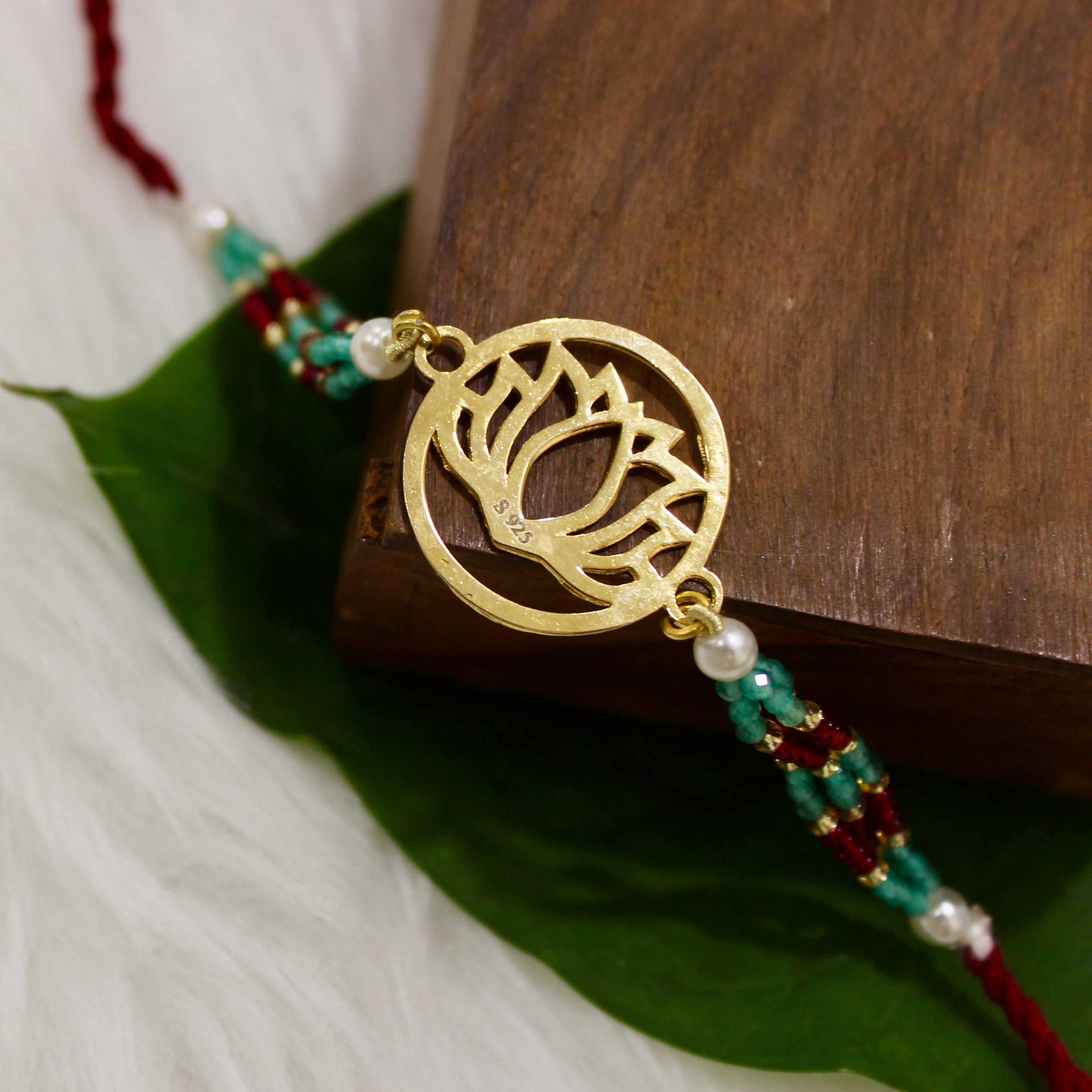Lotus In Gold Polish Maroon Thread Rakhi In 925 Silver