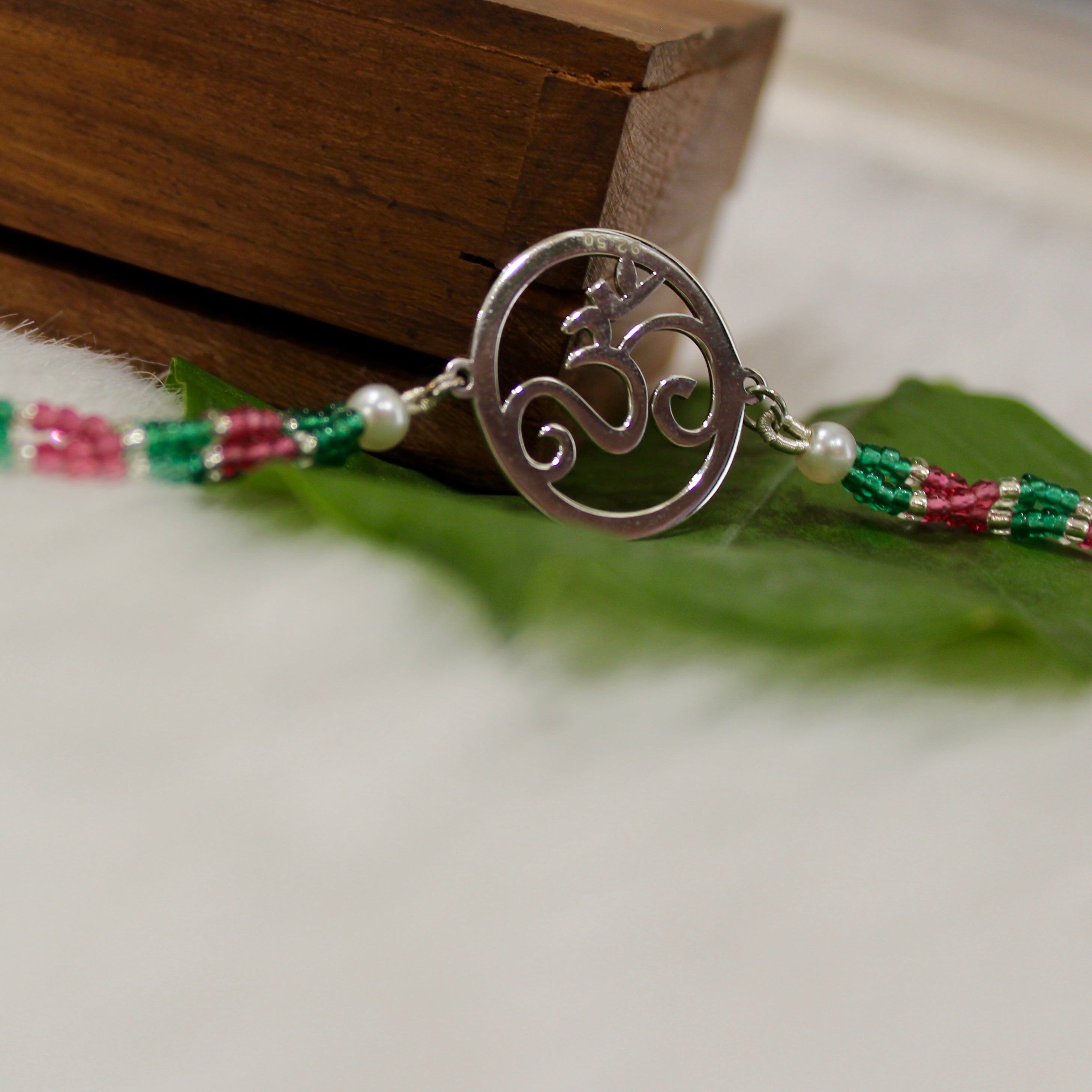 Om In Circle Pink Thread Rakhi In 925 Silver