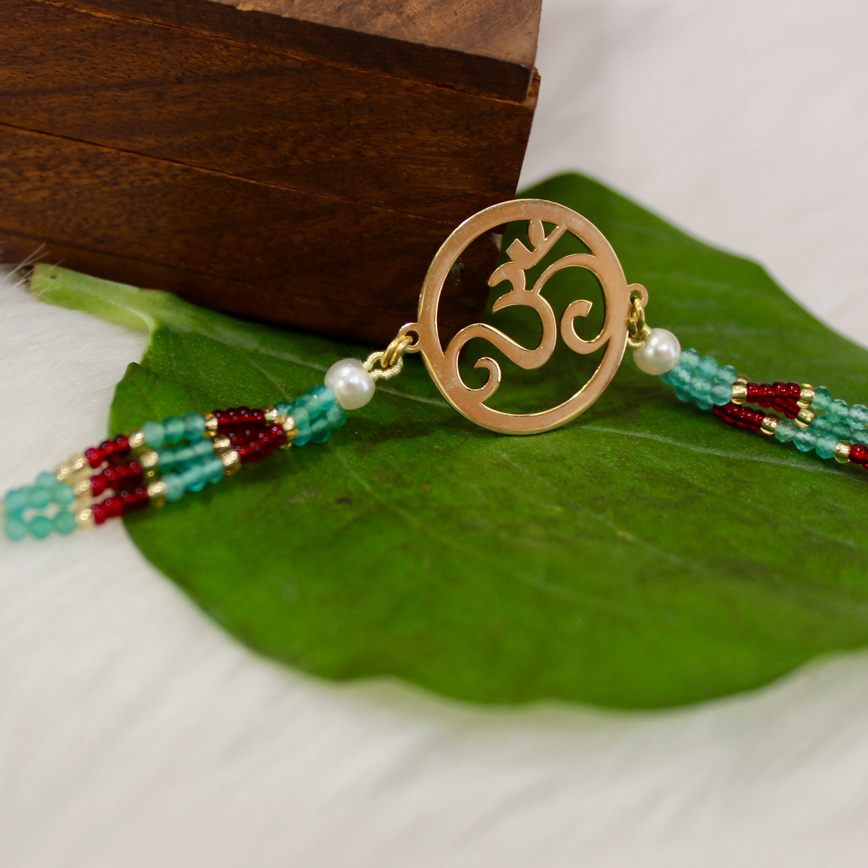 Om In Circle Gold Polish Maroon Thread Rakhi In 925 Silver