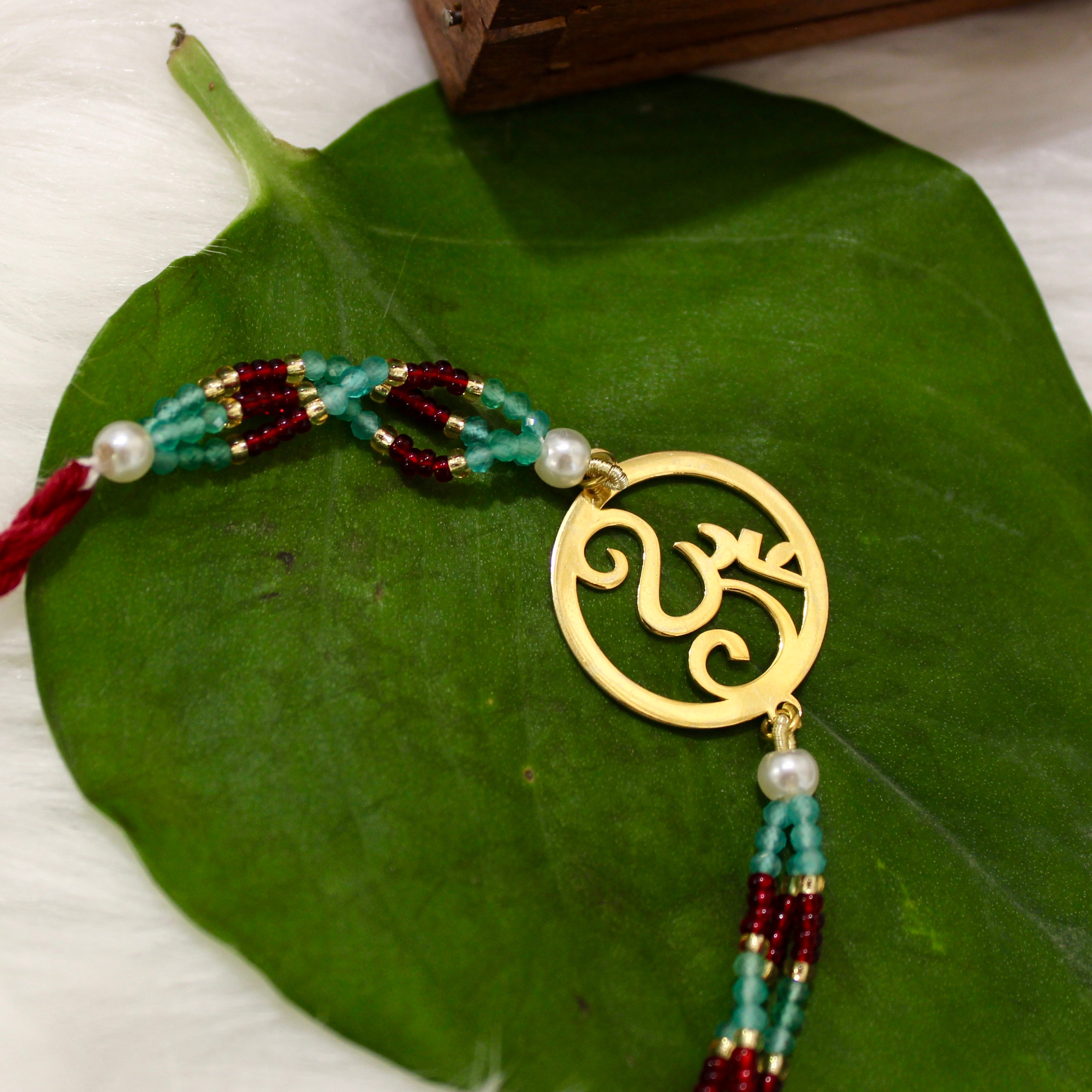 Om In Circle Gold Polish Maroon Thread Rakhi In 925 Silver