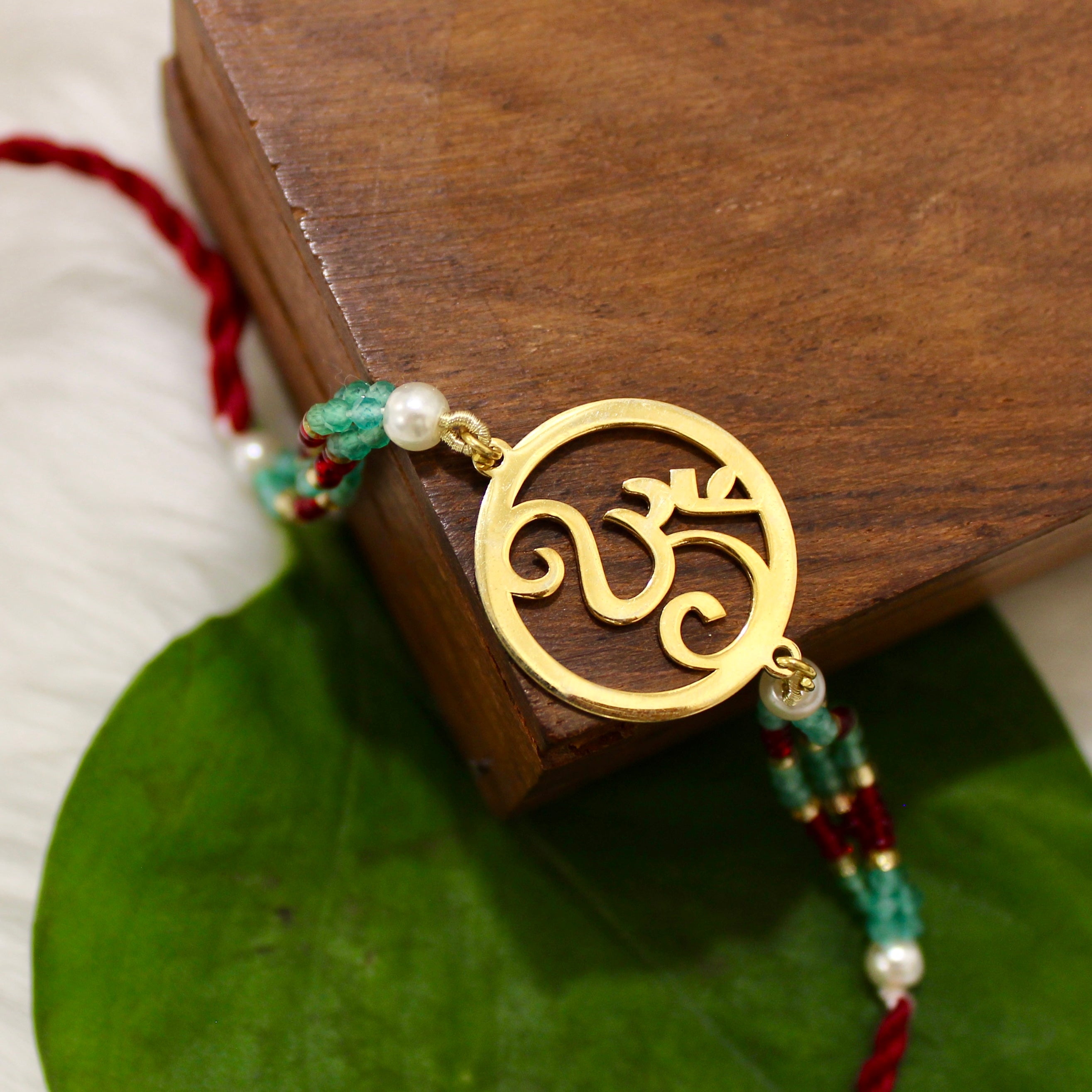 Om In Circle Gold Polish Maroon Thread Rakhi In 925 Silver