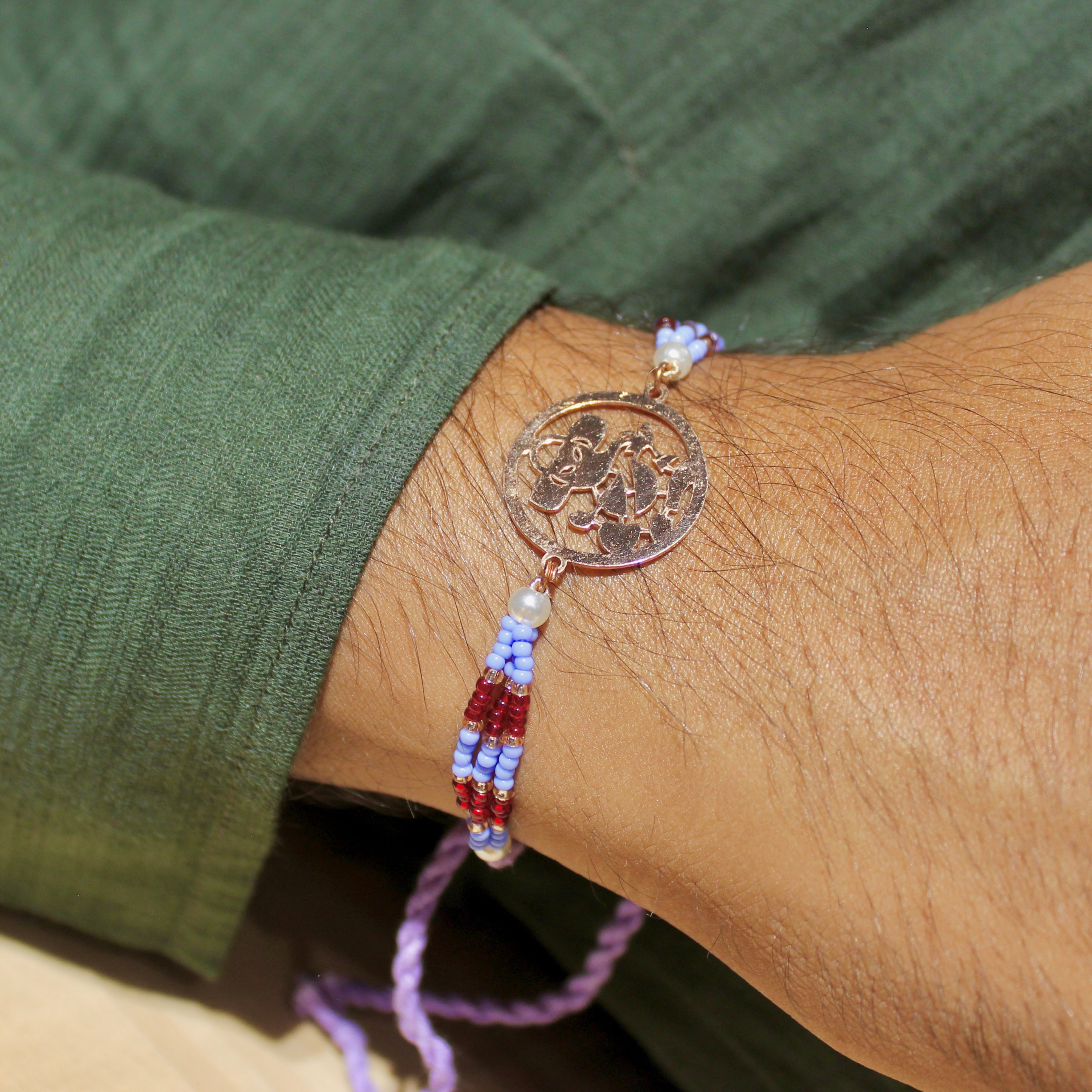 Ganesh Ji In Rosegold Polish With Purple Thread Rakhi In 925 Silver