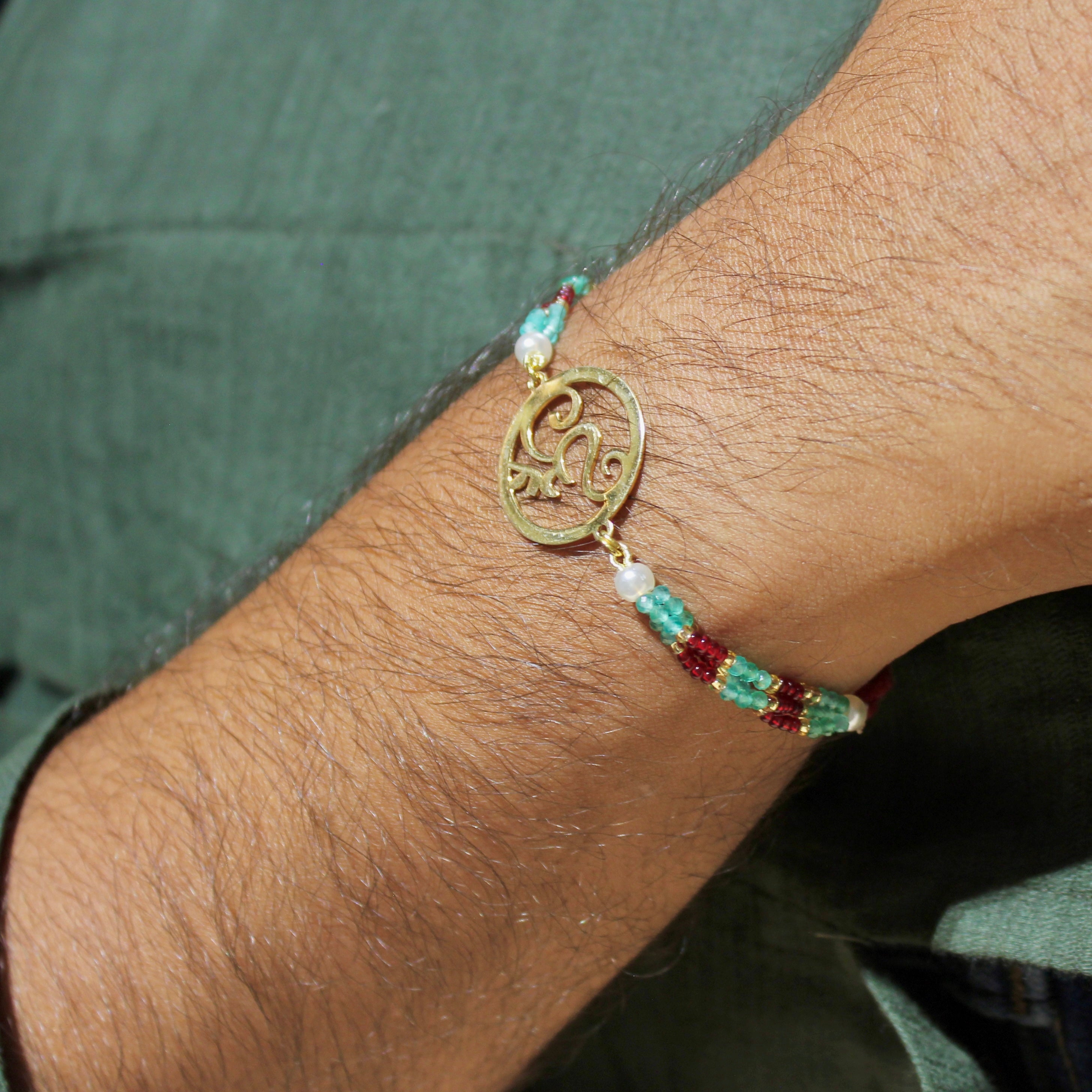 Om In Circle Gold Polish Maroon Thread Rakhi In 925 Silver