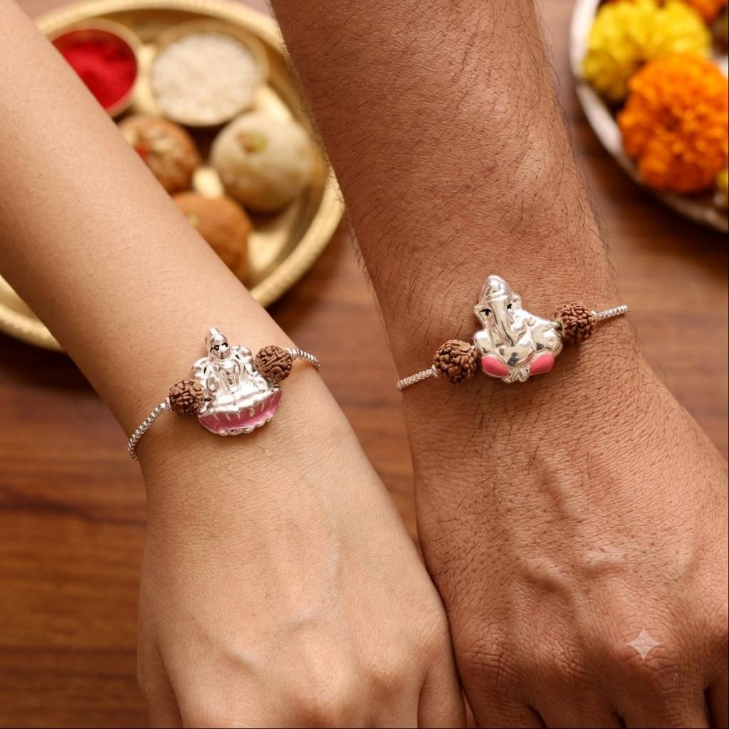 Two silver-toned charm bracelets with small figurines and brown beads worn on a person's wrists, shown against a warm wooden table with decorative food and flower props in the background.