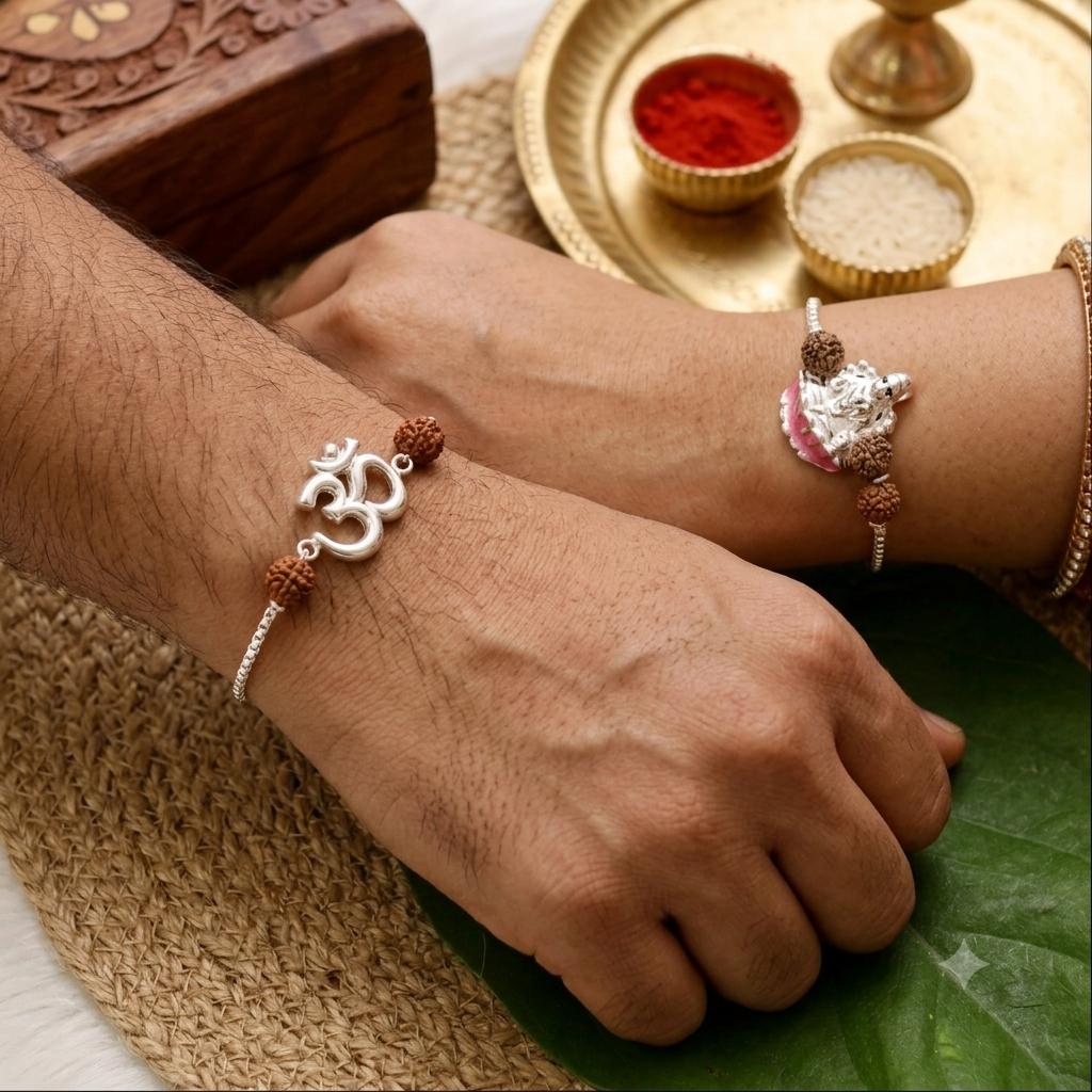 Two silver and brown beaded bracelets worn on a person's wrists, displayed over a woven mat with traditional Indian ceremonial props including a brass plate, red powder, and a wooden box.