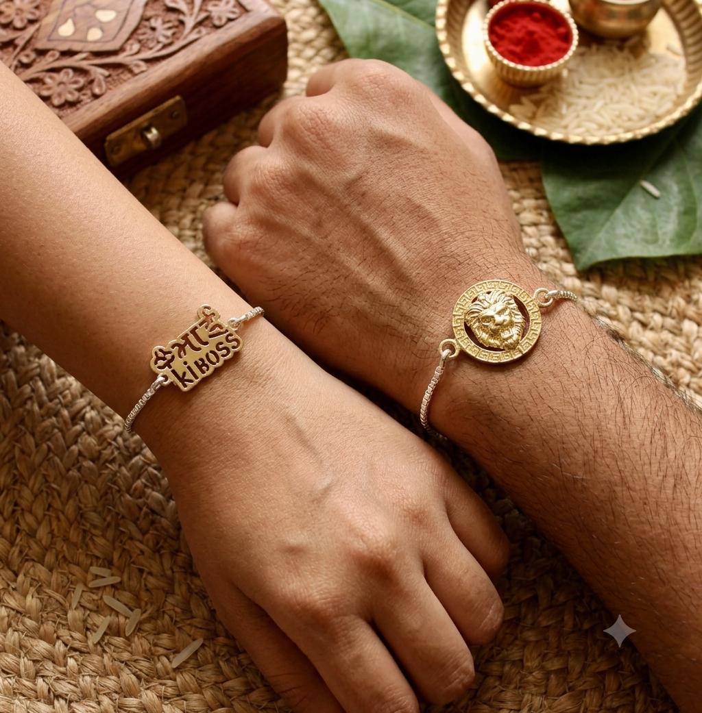 Two people wearing matching gold and silver bracelets, with one bracelet engraved with '4.14 KISS' and the other featuring a lion head charm.