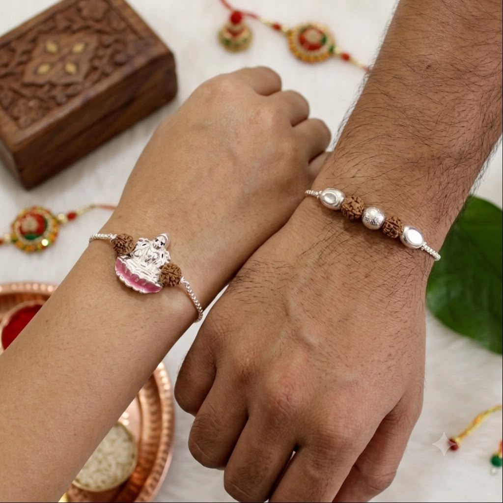 Two silver-toned beaded bracelets with small decorative charms worn on a man's and woman's wrists, shown in a styled close-up with traditional jewelry and a wooden box in the background.